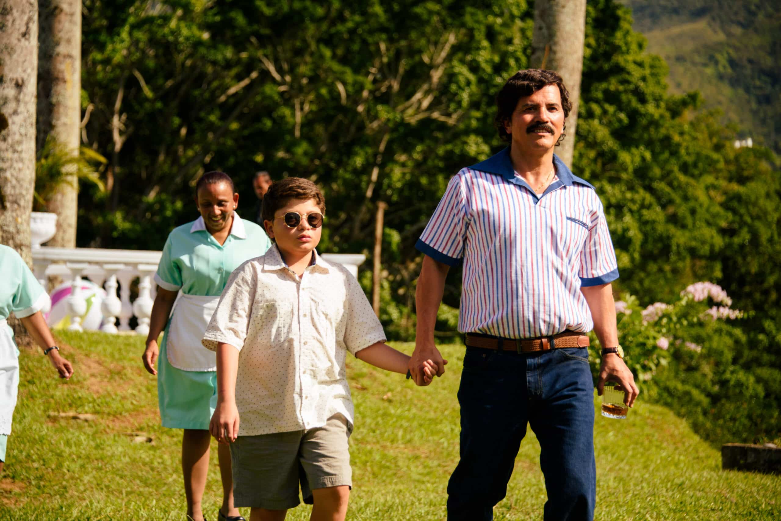DEAR KILLER NANNIES - “Dear Killer Nannies” is a gripping coming-of-age series told through Juampi’s perspective as a child, the son of Colombia’s most notorious drug lord, Pablo Escobar Gaviria. As he grows up, Juampi’s world begins to fracture, shaped by his father’s expanding criminal empire and the constant presence of danger — embodied by the hitmen who serve as his “nannies.” Featuring a stellar cast including John Leguizamo as Pablo Escobar Gaviria, the series explores loyalty, fear, and the loss of innocence, revealing the human cost of a childhood spent inside one of history’s most infamous criminal legacies. (Courtesy of Disney)